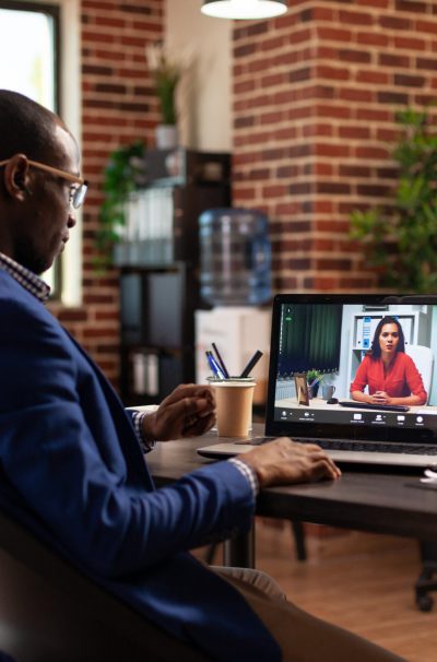 Entrepreneur using online video call to talk to woman on laptop for project planning. Business man meeting with person on remote video conference, having conversation about strategy.